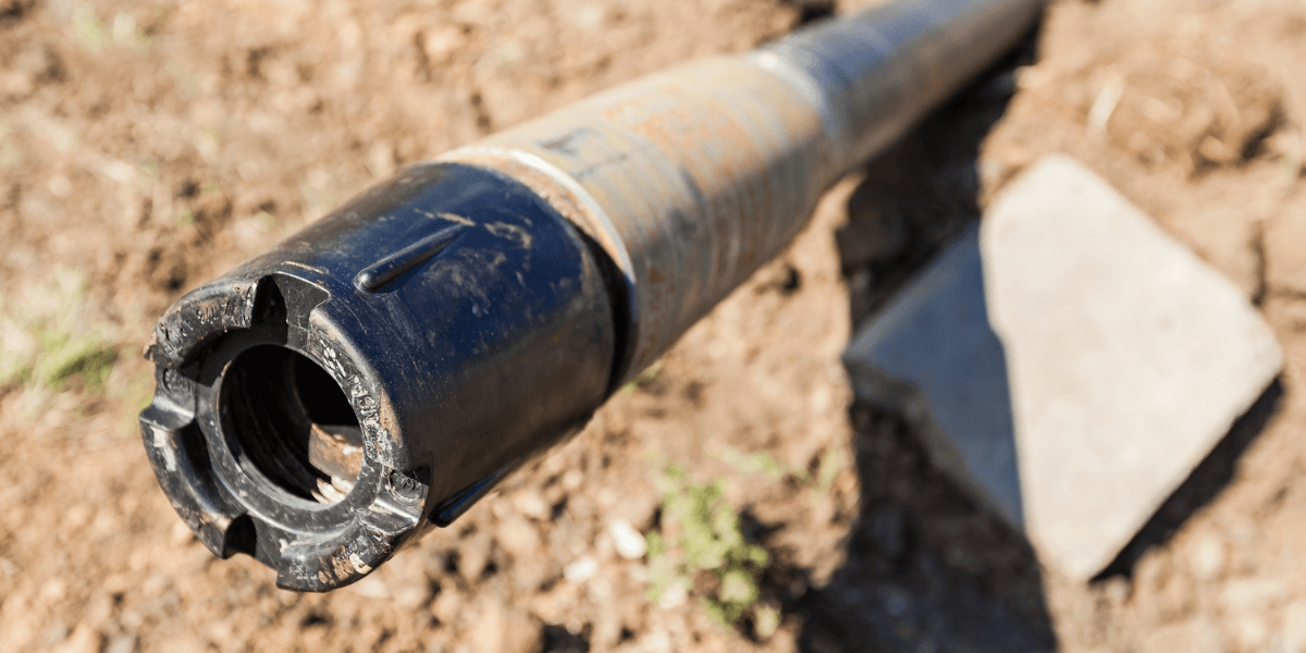 A drill pipe and head coming out of the dirt