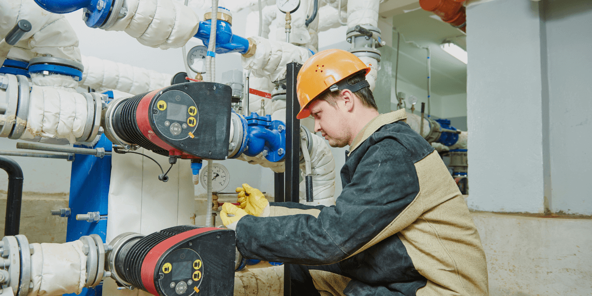 EV Pump & Equipment technician working on pumps wearing an orange hard hat