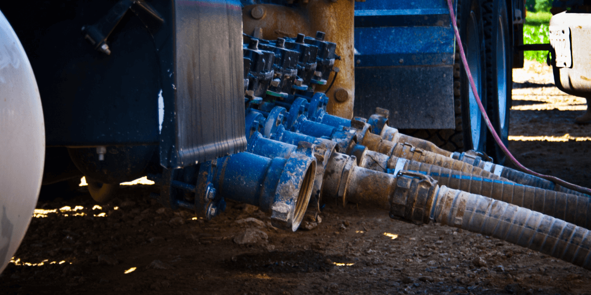 Side view of a well servicing pump truck’s intake manifold, showcasing equipment setup and connections.
